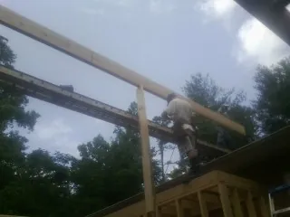 Carpenter setting a ridge beam over a new addition frame — Ice Dam Removal by Roofing Brothers in Rutherford College
