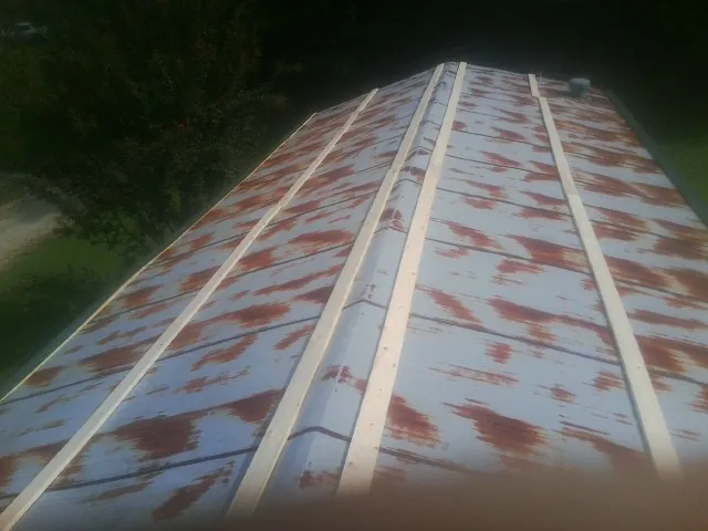 Rusted metal roof panels with new wood purlins before replacement — Storm Damage Roof Repair in Rutherford College by Roofing Brothers