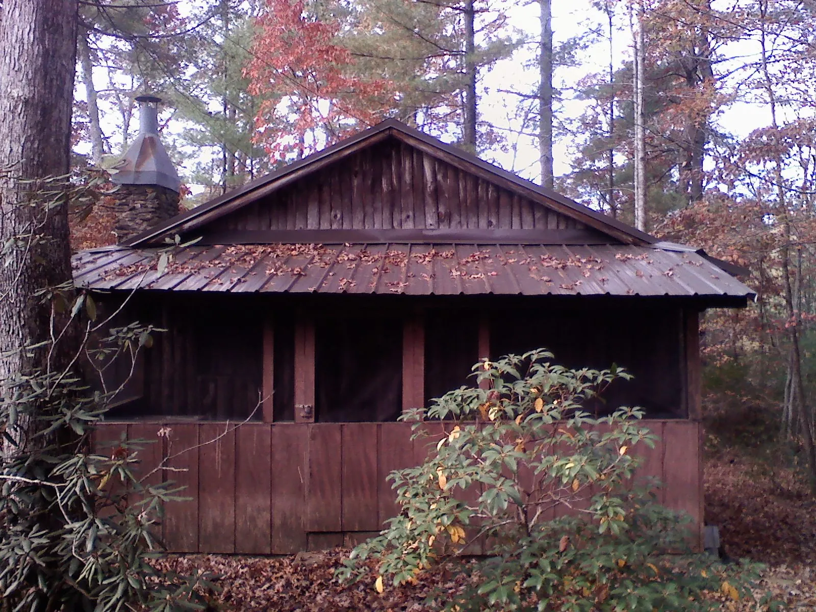 Metal roof over the screened porch of a rustic cabin in Rutherford College