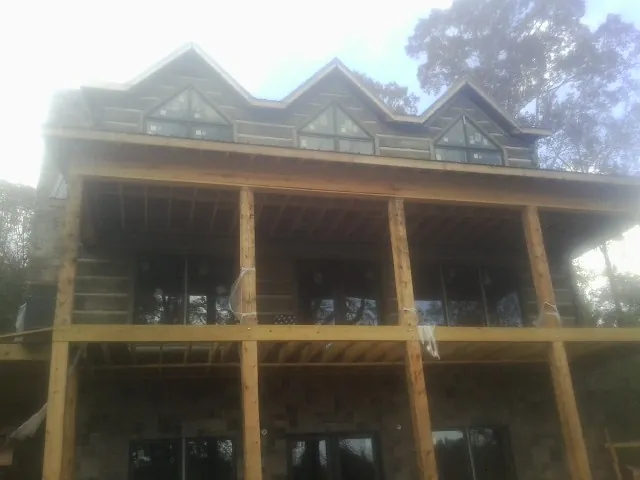Dormers and porch framing on a large log home under construction — Roof Coating work by our crew in Rutherford College