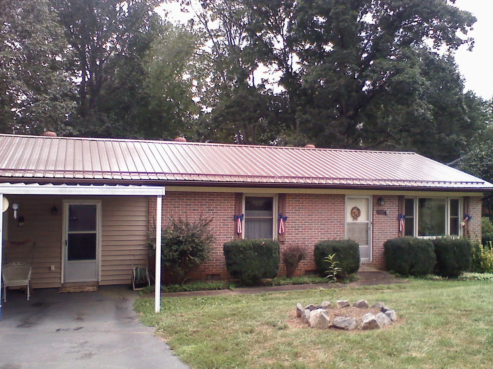 Bronze metal roof and carport on a brick ranch home — Roof Repair work by our crew in Rutherford College