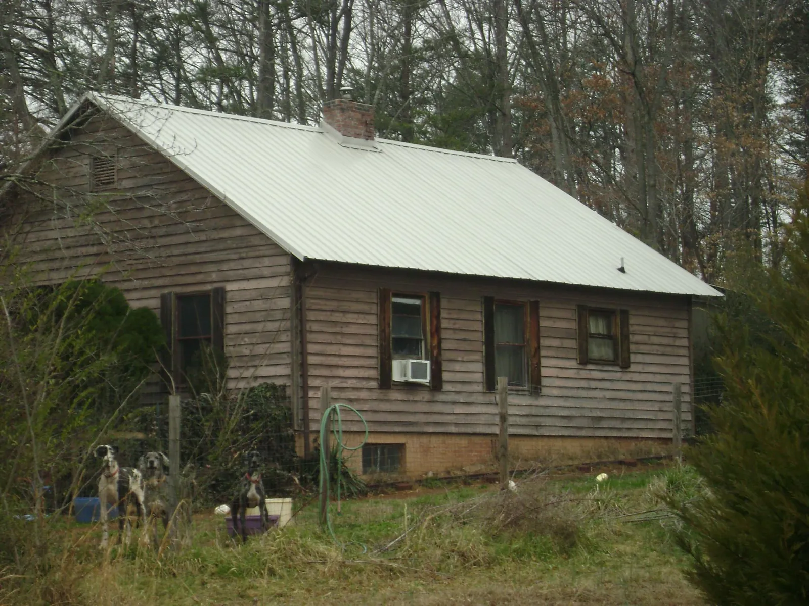 White metal roof on an old wood sided farmhouse, from a Metal Roof Installation job in Rutherford College